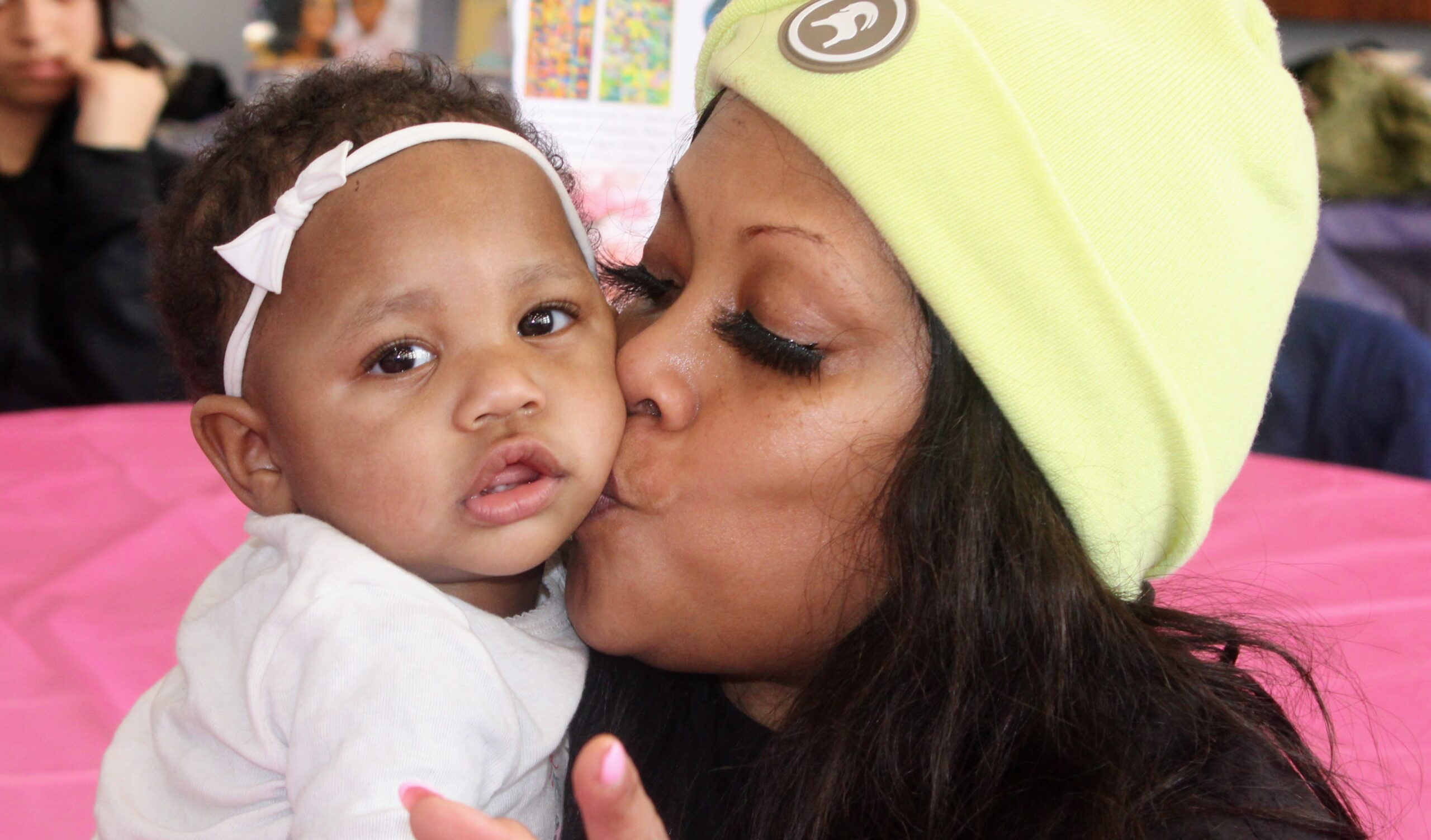 A mother holding and kissing her baby at a Platform of Hope gathering